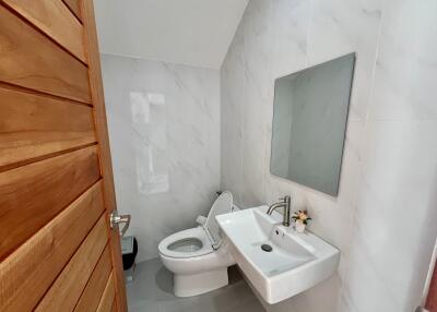 Modern bathroom with marble tiles and wooden door