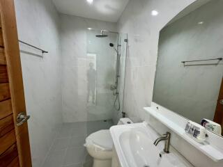 Modern bathroom with large glass shower and white fixtures