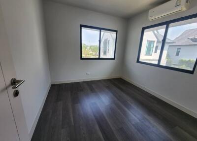 Spacious and well-lit empty bedroom with hardwood floors