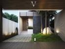 Modern home exterior at dusk with illuminated pathway