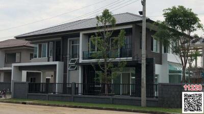 Modern two-story house with gray and white exterior, large windows, and a balcony