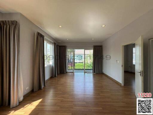 Spacious living room with ample natural light and hardwood floors