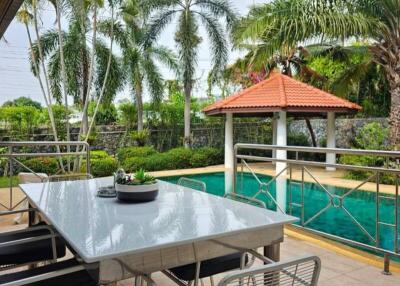 Spacious outdoor patio with tropical landscaping and dining area