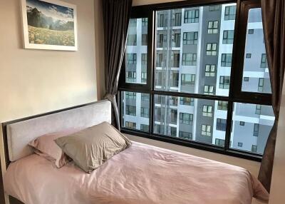 Cozy bedroom with large window view of the city