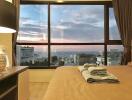 Cozy bedroom with a scenic sunset view through large windows