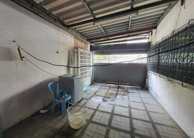 Spacious uncovered garage area with tiled flooring and corrugated metal roof