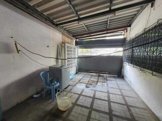 Spacious uncovered garage area with tiled flooring and corrugated metal roof