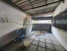 Spacious uncovered garage area with tiled flooring and corrugated metal roof