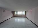 Spacious living room with large windows and tiled floor