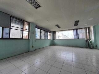 Spacious empty room with large windows and tiled flooring