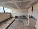 Spacious but unfinished kitchen with tiled flooring and natural light