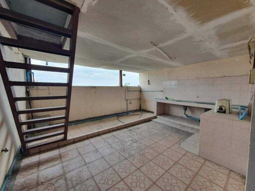 Spacious kitchen with tile flooring and large windows in need of renovation