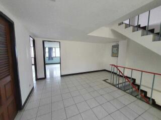 Spacious living room with staircase and tiled flooring