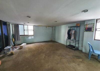 Spacious unfurnished living room with large windows and a worn carpet