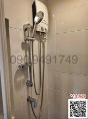 Modern wall-mounted water heater with handheld showerhead in a tiled bathroom