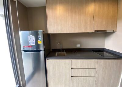 Modern kitchen with stainless steel refrigerator and wooden cabinetry