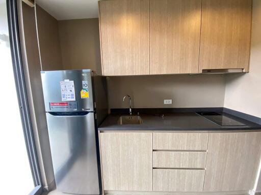 Modern kitchen with stainless steel refrigerator and wooden cabinetry