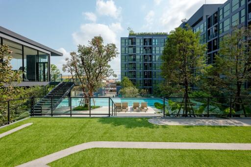 Modern residential building with outdoor swimming pool and lounge chairs