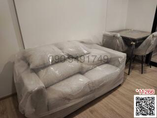 Newly delivered furniture wrapped in plastic in an apartment living room