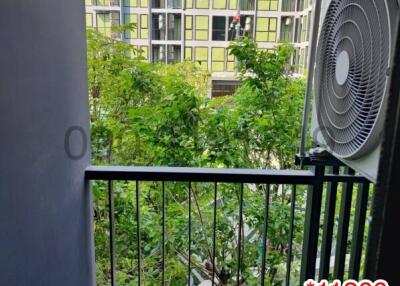 Compact balcony with air conditioning units and a view of neighboring building and greenery