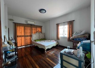 Spacious bedroom with natural light and hardwood floors