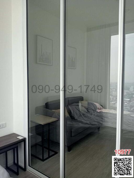 Modern bedroom with city view through glass wall