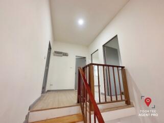 Bright interior view of a home staircase with wooden rails