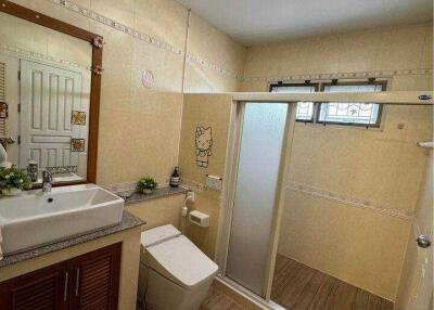 Modern bathroom with wooden floor and beige wall tiles