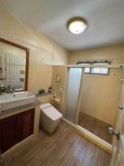 Modern bathroom with wooden floor and beige wall tiles