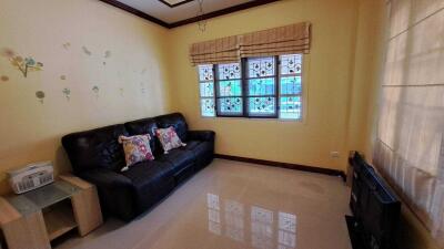 Spacious living room with large window and comfortable seating