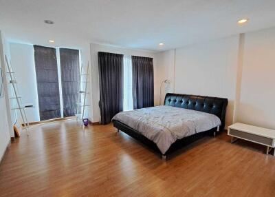 Spacious bedroom with large bed and hardwood floors