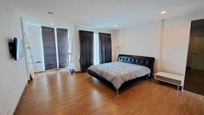 Spacious bedroom with large bed and hardwood floors