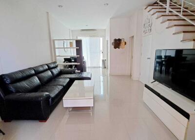 Spacious living room with modern furniture and staircase