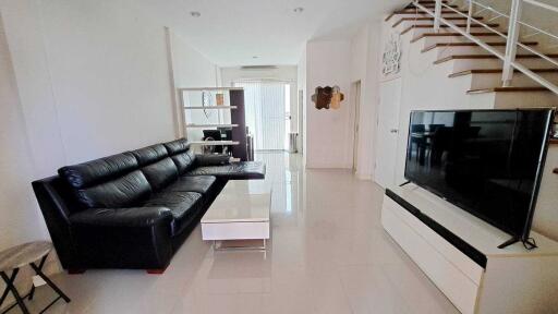 Spacious living room with modern furniture and staircase