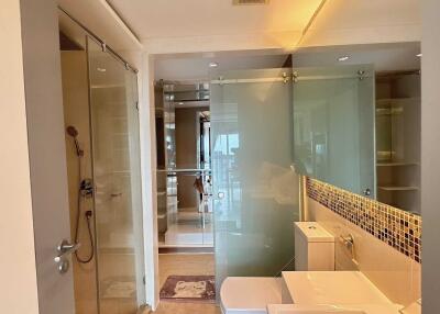 Modern bathroom interior with glass shower and tiled wall
