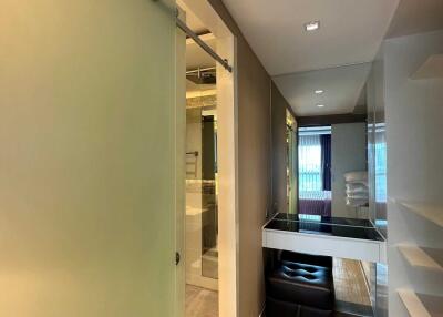 Modern hallway leading to a stylish bathroom with sliding door