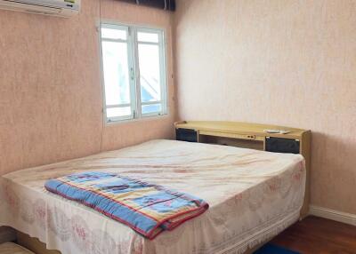 Compact bedroom with double bed, wall-mounted air conditioner, and natural light