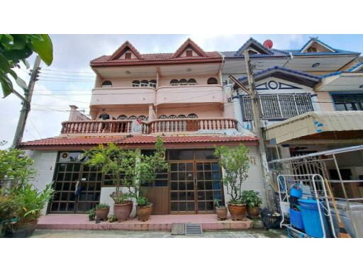 Three-story residential building with balcony and terrace