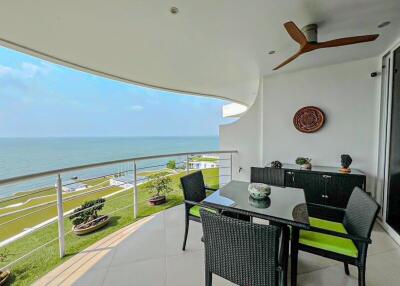 Spacious balcony with ocean view, dining set, and ceiling fan