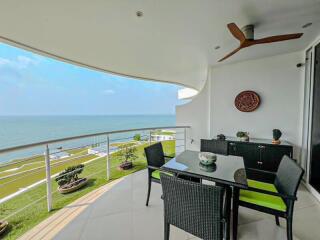 Spacious balcony with ocean view, dining set, and ceiling fan