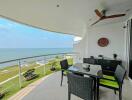 Spacious balcony with ocean view, dining set, and ceiling fan