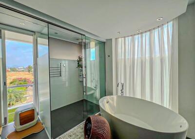 Modern bathroom with floor-to-ceiling windows and standalone bathtub