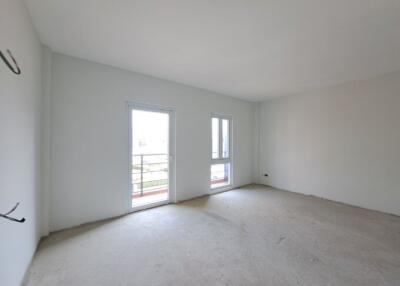 Spacious unfurnished bedroom with large windows and balcony access
