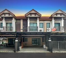 Townhouse complex exterior view showing the facade of multiple units with balconies and carports