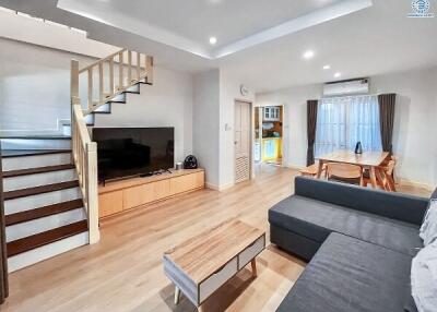 Modern living room with staircase and open dining area