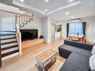 Modern living room with staircase and open dining area