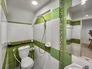 Modern bathroom interior with green and white tiles