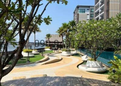 Luxurious residential complex with a pathway leading to a pool by the waterfront