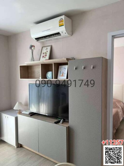 Cozy bedroom interior with mounted air conditioning unit and entertainment set-up