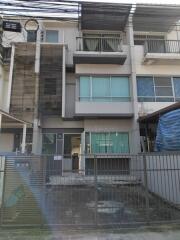 Modern multi-story residential building with fence